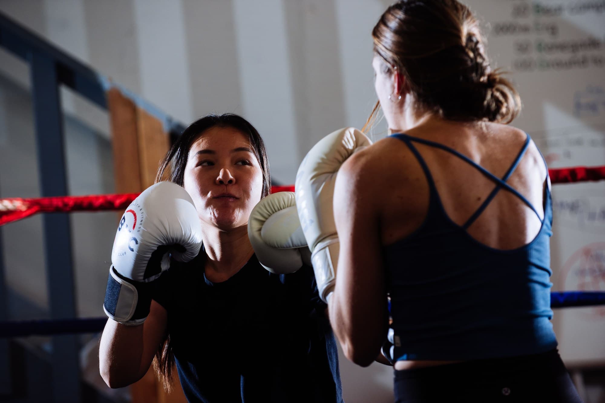Two women squaring up during a women's boxing class at Ballard Barbell and Boxing Club